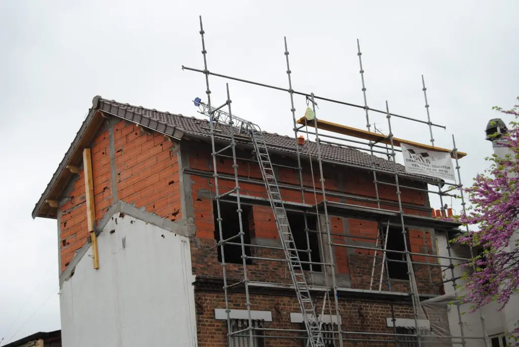Grande maison en travaux avec échafaudage Toits et Moi