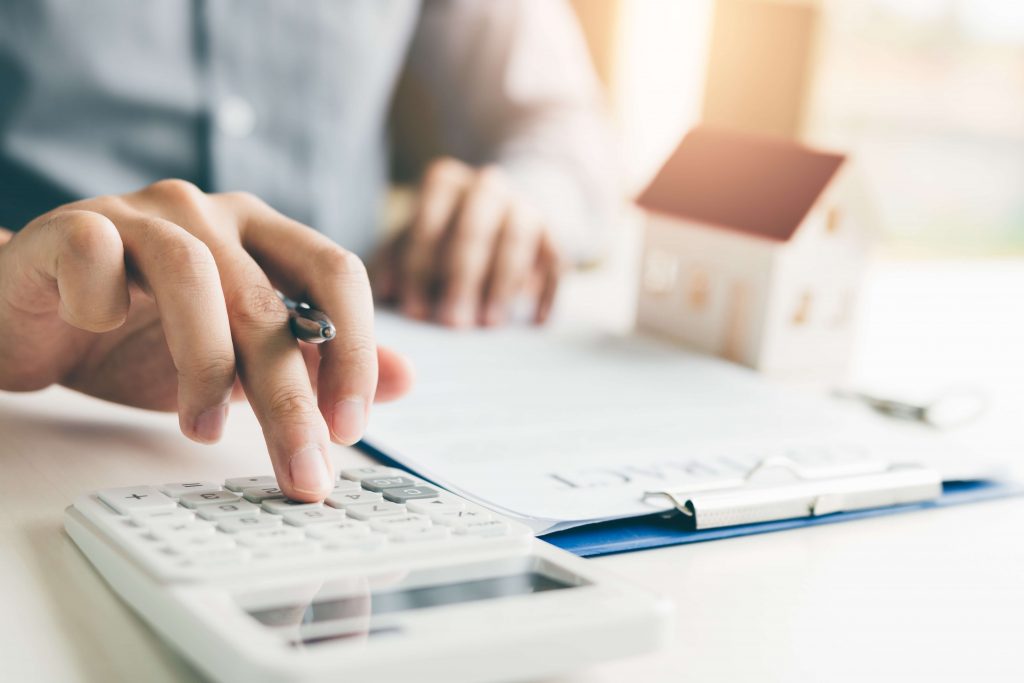 Homme utilisant une calculatrice et écrivant des données
