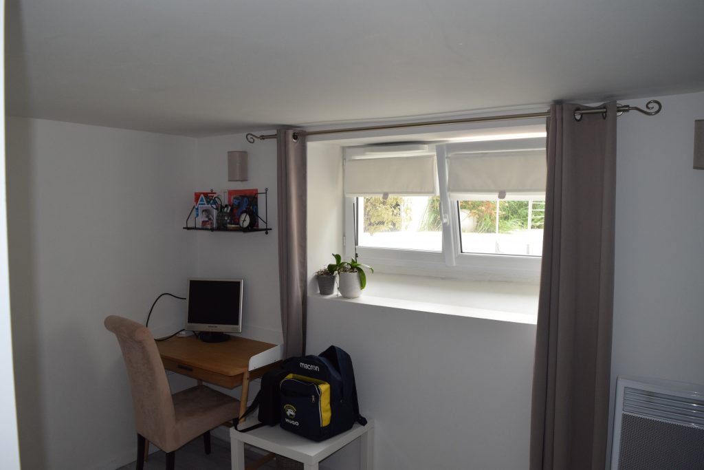 Chambre simple avec un petit bureau et une décoration minimaliste